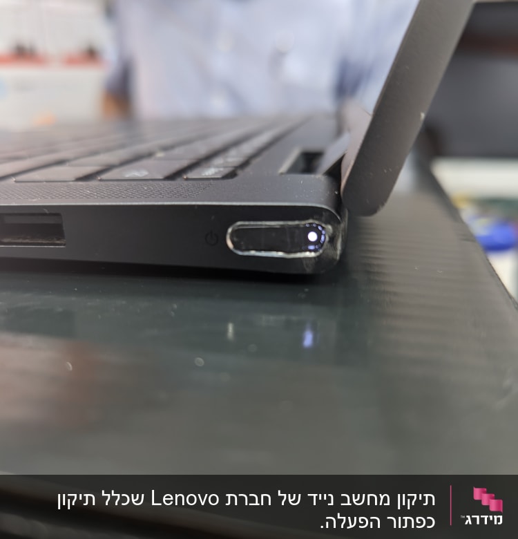 מחשב נייד פתוח עם כפתור הפעלה מואר